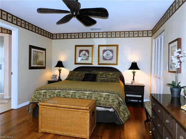 Bedroom featuring a closet, dark wood-type flooring, and a ceiling fan
