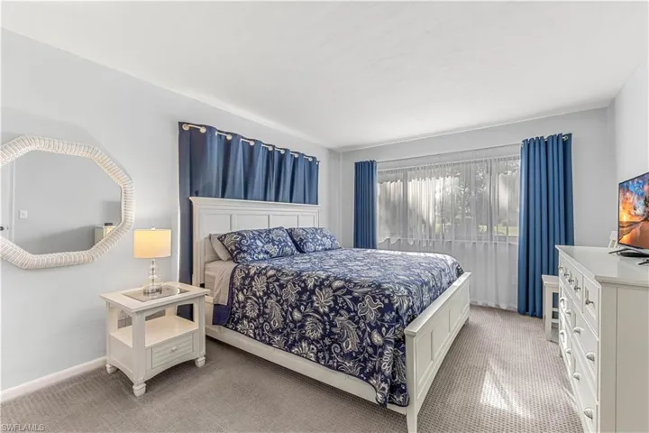 View of master bedroom with newer carpet and view of the golf course