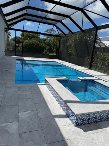 View of pool with a spa, lanai and a patio area