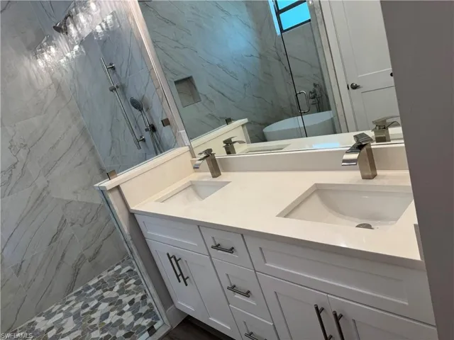 Main bathroom with walk in shower plus bathtub and double sink vanity