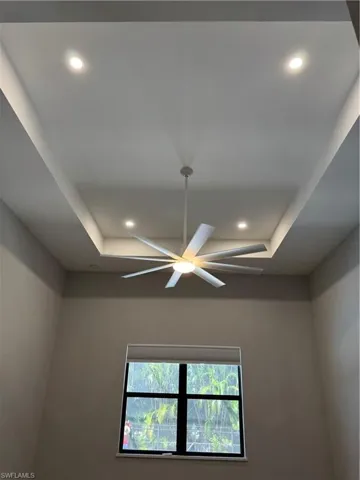 Details of main bedroom with ceiling fan and a tray ceiling