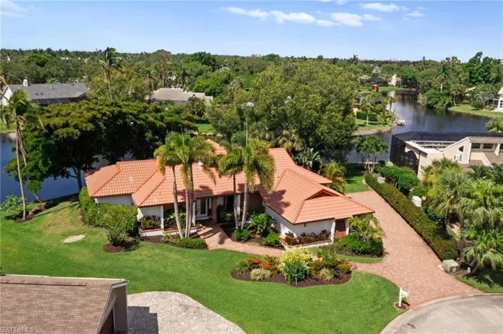 Aerial view with tile roof, water view, paver driveway