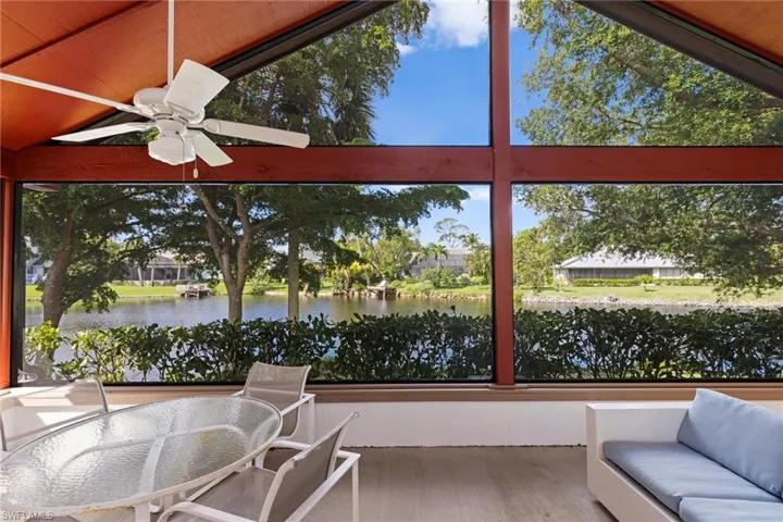 Screened lanai with lofted ceiling, a water view, and ceiling fan
