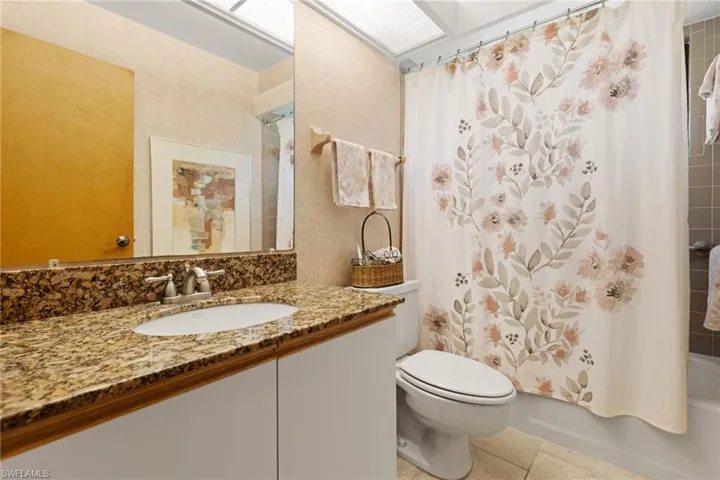 Full bathroom featuring vanity, tile patterned floors, toilet, and shower / tub combo