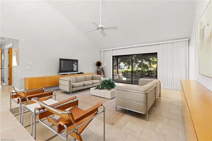 Tiled living room with high vaulted ceiling and ceiling fan