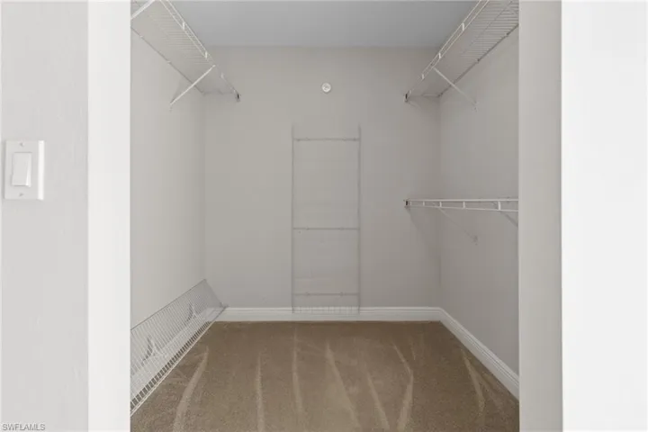 2 separate large walk in closets featuring carpet floors