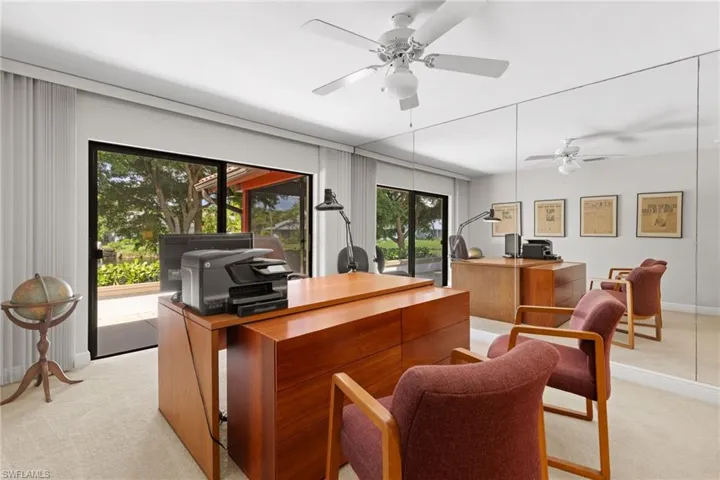 Carpeted home office with a healthy amount of sunlight and ceiling fan