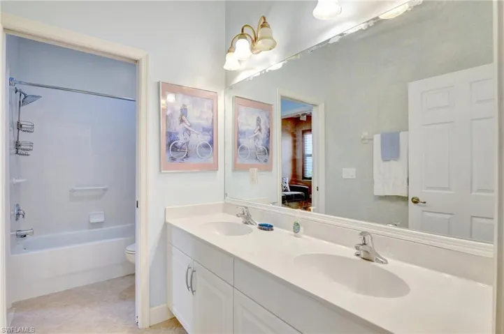 Full bath with ensuite bathroom, a sink, double vanity, and toilet
