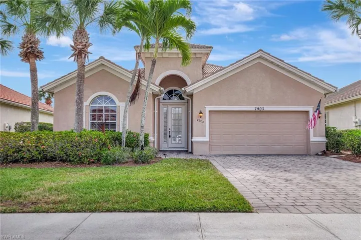 Mediterranean / spanish home with french doors, a front lawn, a garage, stucco siding, and decorative driveway