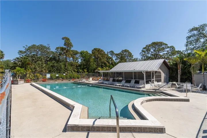 Community pool featuring a patio area, fence, and a sunroom
