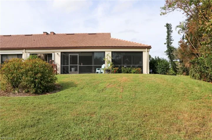 Back of property featuring a lawn and a sunroom