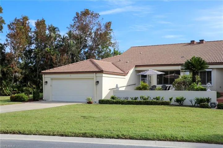 View of front of property featuring a garage and a front lawn