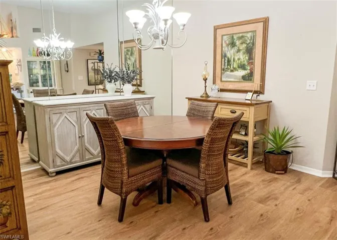 Dining area with light hardwood / wood-style flooring and a chandelier