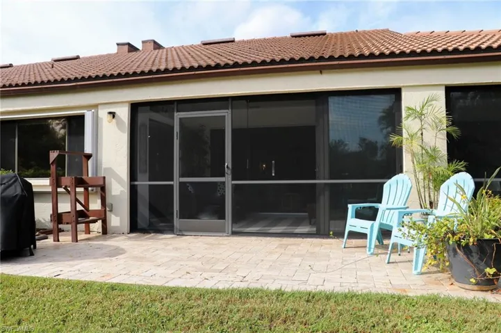 Back of property with a sunroom and a patio