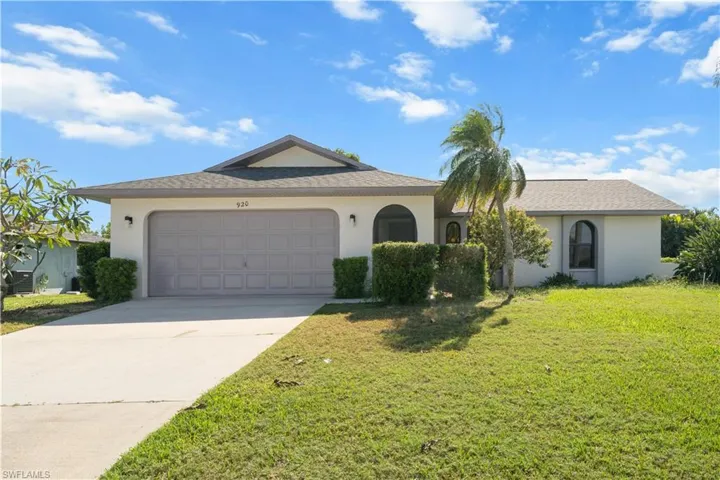 Ranch-style house with stucco siding, driveway, a front lawn, and a garage