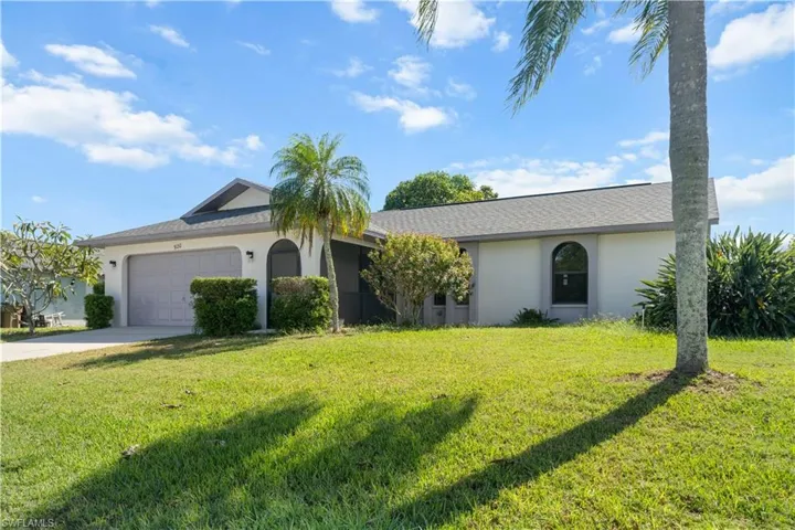 Single story home with stucco siding, a front yard, an attached garage, and driveway