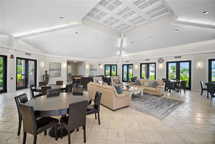 Dining area featuring vaulted ceiling, light tile patterned floors, recessed lighting, and french doors