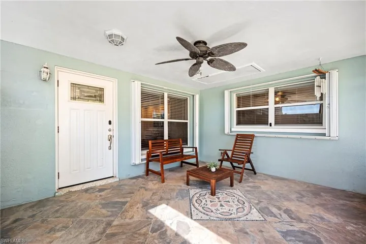 Doorway to property with a ceiling fan, stucco siding, and a patio area