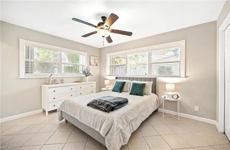 Bedroom with ceiling fan and light tile patterned floors