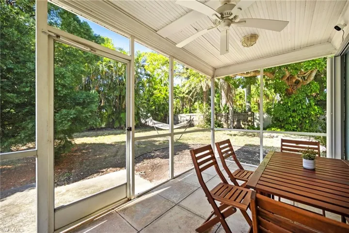 Unfurnished sunroom with a ceiling fan and outdoor dining area