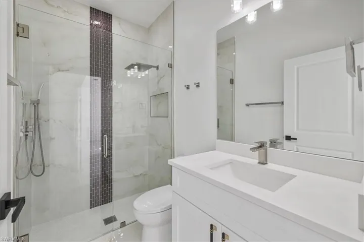 Bathroom with vanity and a marble finish shower