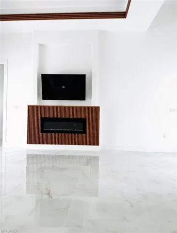 Kitchen with light marble finish floors, a peninsula, decorative light fixtures, appliances with stainless steel finishes, and recessed lighting