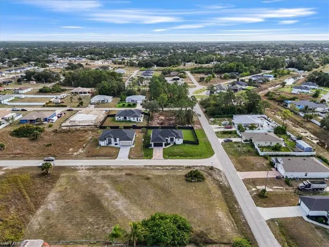 Aerial view of property and surrounding area with nearby suburban area