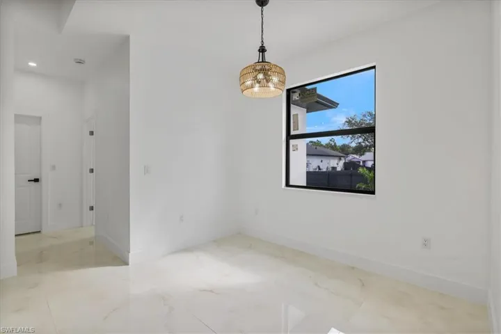 Unfurnished dining area with light marble finish floors and a chandelier