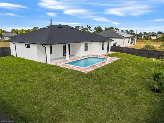Rear view of house featuring a fenced backyard, stucco siding, and a patio
