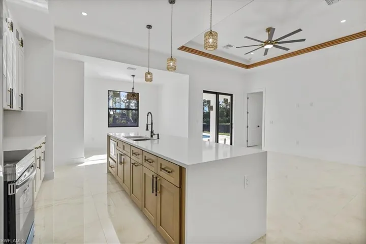 Kitchen featuring plenty of natural light, white cabinetry, stainless steel electric range oven, recessed lighting, and ornamental molding