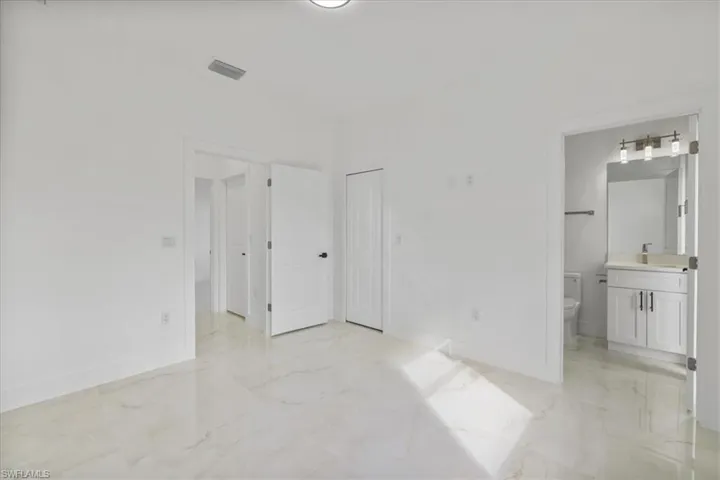 Laundry area featuring light marble finish flooring, hookup for an electric dryer, hookup for a washing machine, and cabinet space