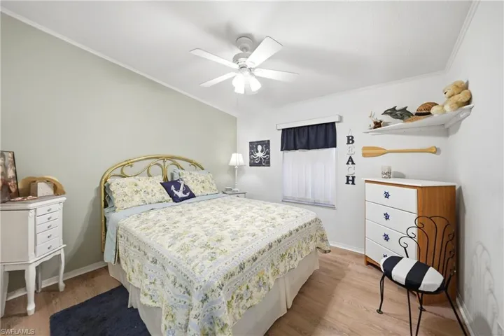 Bedroom featuring wood-finish flooring, a ceiling fan, and a window with blinds