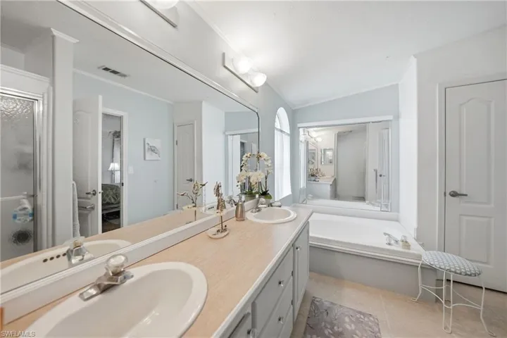 Dual vanity with oval sinks, laminate countertops, and light gray cabinetry