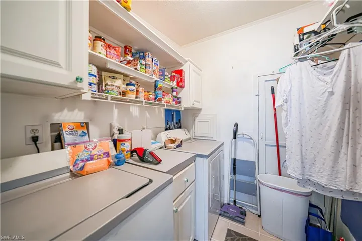 Utility room featuring white cabinetry, open shelving, and neutral countertops