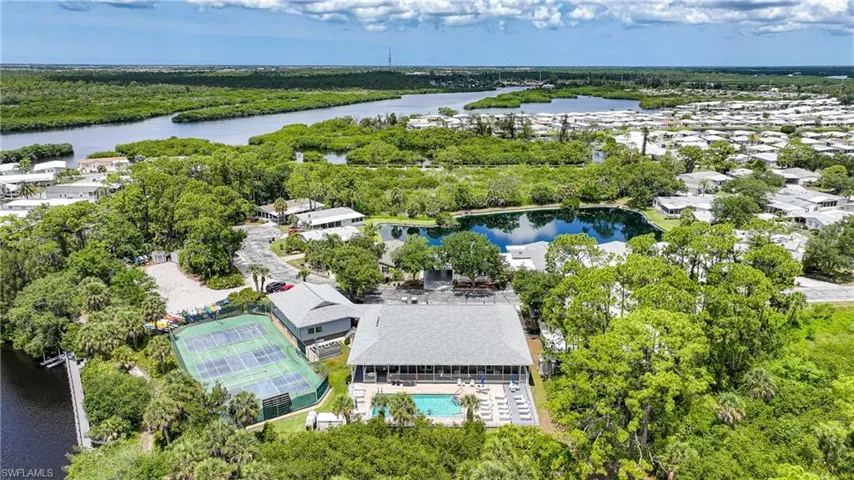 Riverfront community featuring a tennis court, swimming pool, and wooded grounds