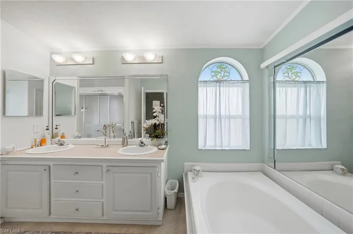 Dual vanity with integrated sinks, ample counter space, and wall-mounted lighting
