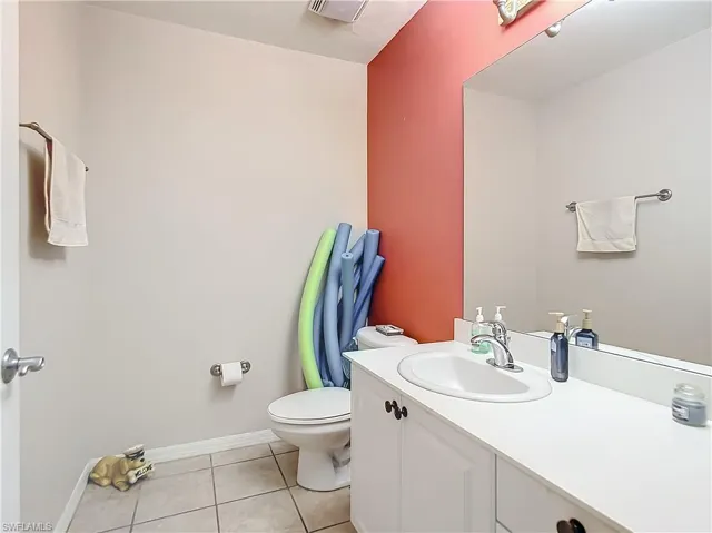 Half Bathroom with tile patterned flooring, vanity, and toilet