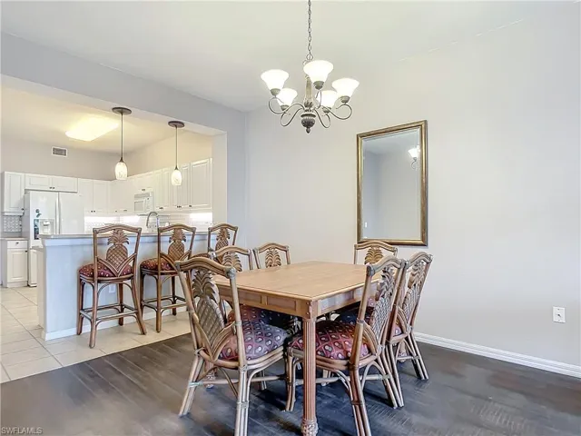 Dining space with light tile patterned flooring and an inviting chandelier