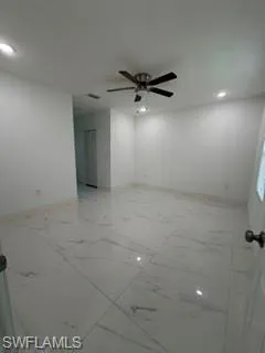 Expansive room featuring large format tile flooring, recessed lighting, and a ceiling fan