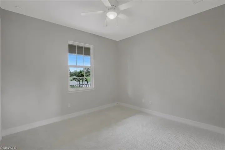 Spare room featuring carpet and ceiling fan