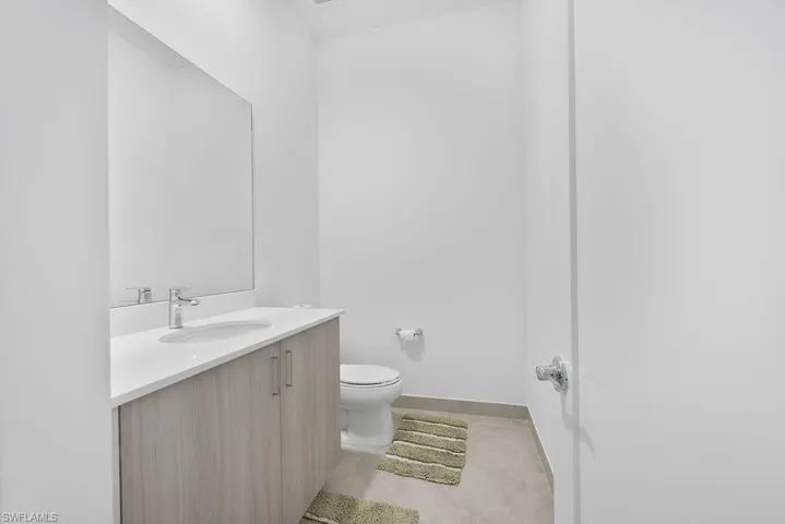 Bathroom with tile floors, vanity, and toilet