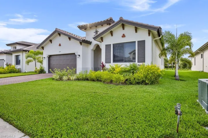 Mediterranean / spanish home featuring a garage and a front yard