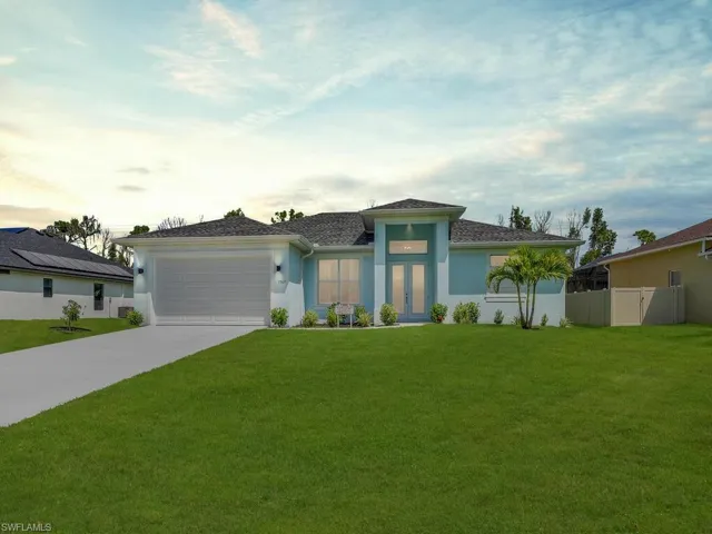 Prairie-style home featuring french doors, concrete driveway, a garage, and stucco siding
