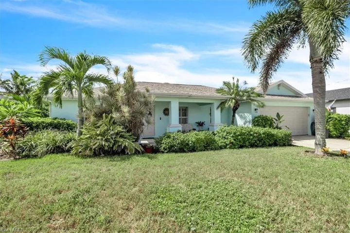 Light blue stucco exterior with a covered front porch and an attached garage