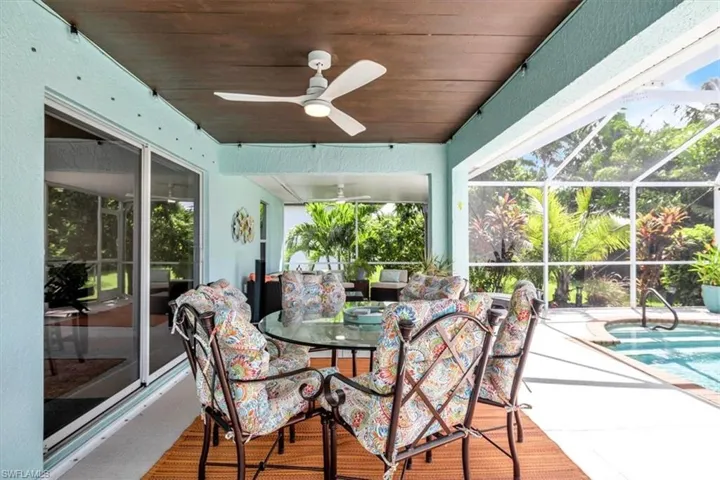 Covered patio with a wood-finish ceiling, ceiling fan, and sliding glass doors