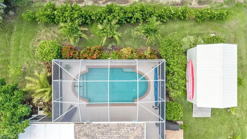 Screened-in oval swimming pool with integrated spa