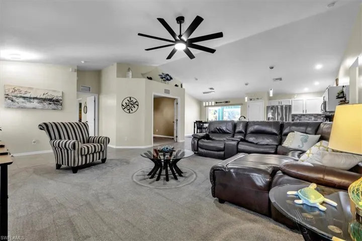 Vaulted ceiling with an installed ceiling fan, recessed lighting, and light-toned wall paint