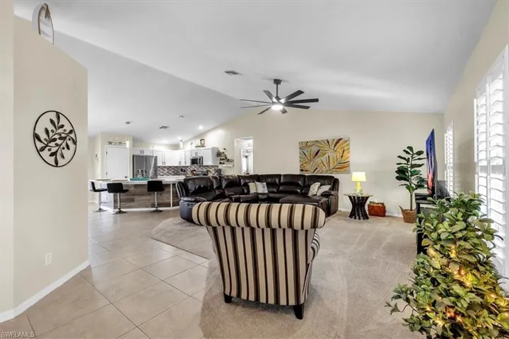 Vaulted ceilings, a contemporary ceiling fan, and carpeted flooring define the living space