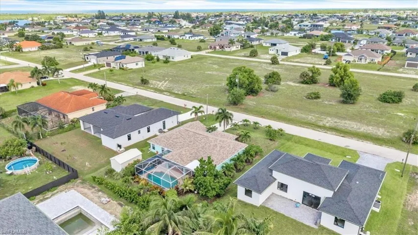 Aerial perspective showcasing residential properties with a mix of established and new construction, diverse rooflines, and varied lot sizes
