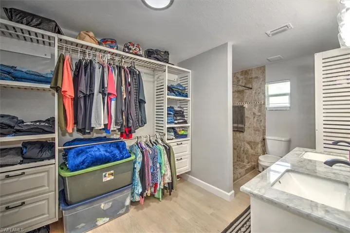 Spacious closet with a sink, visible vents, and light wood-type flooring
